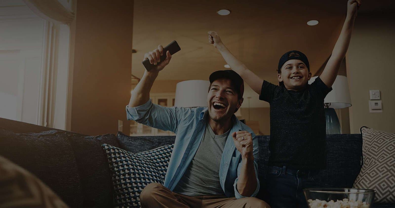 Vader en zoon vieren feest tijdens het kijken van live sport met Pandora IPTV